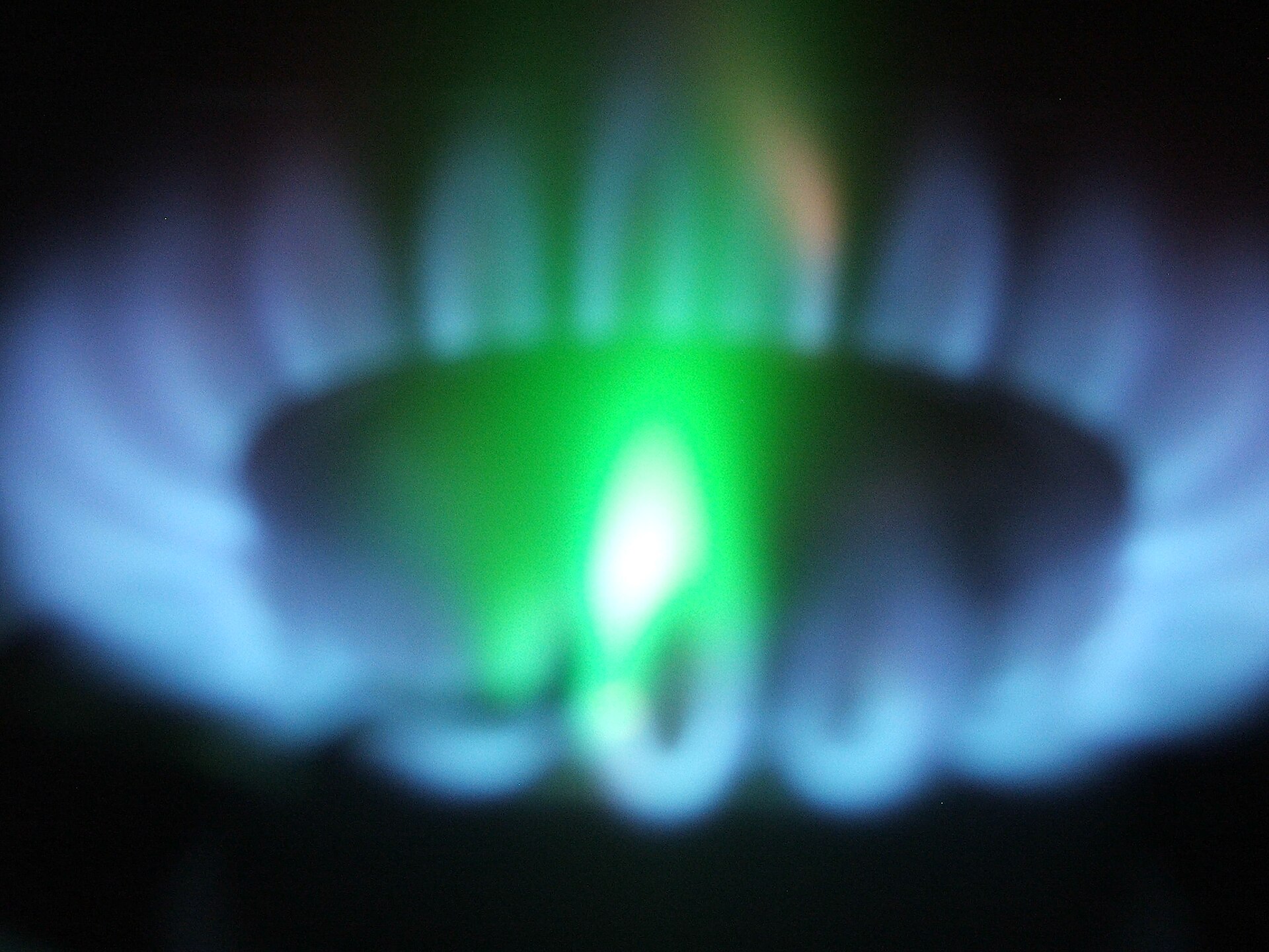A zinc sample producing a pale blue-green flame in a laboratory flame test.