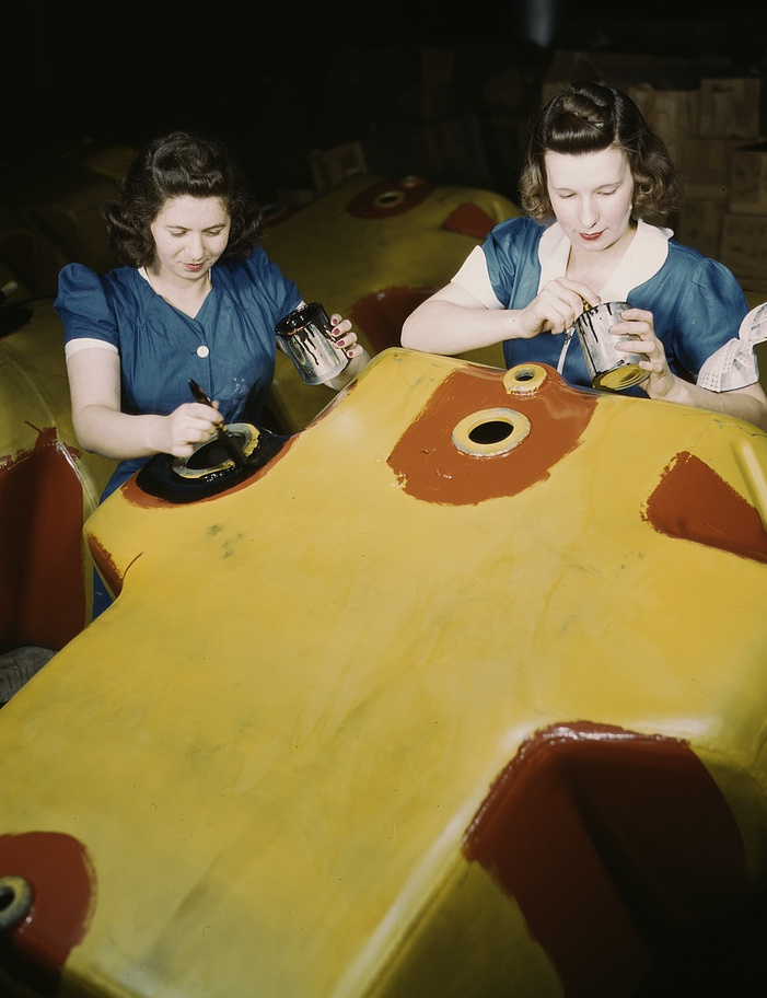 Color photograph of women assembling aircraft in a wartime factory