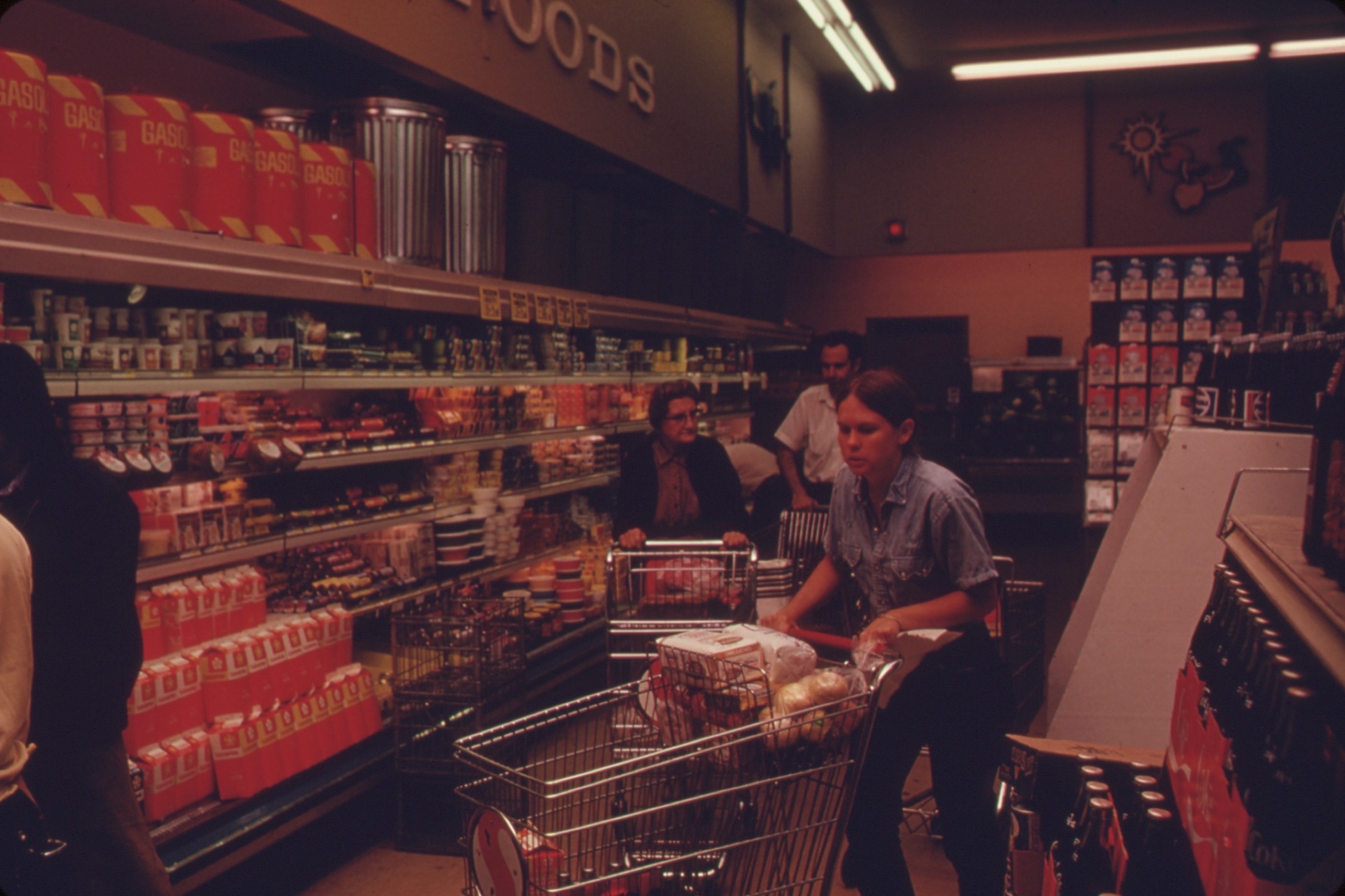 Shoppers selecting groceries inside a large supermarket.