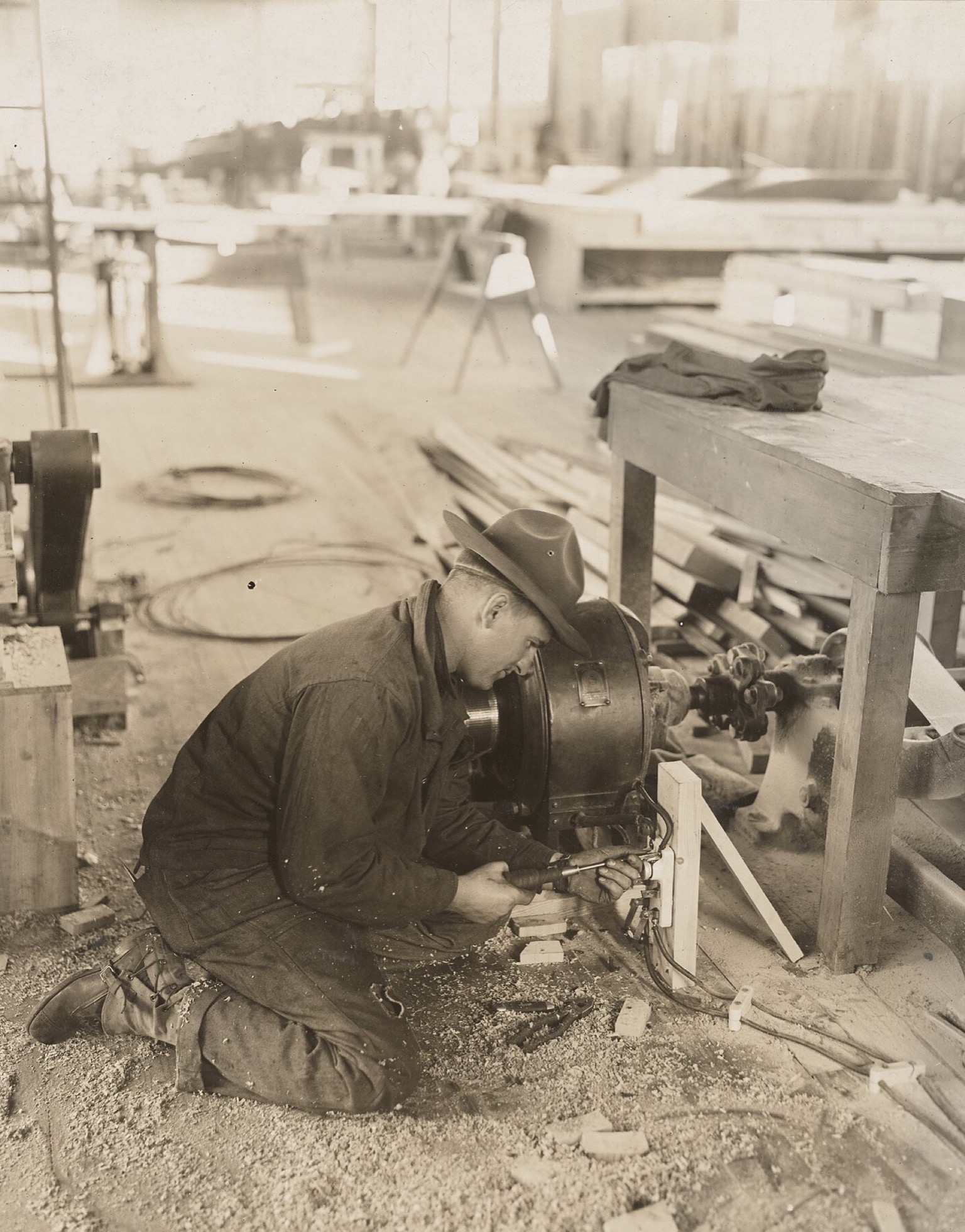 A worker installing electrical equipment in an airplane-production factory.