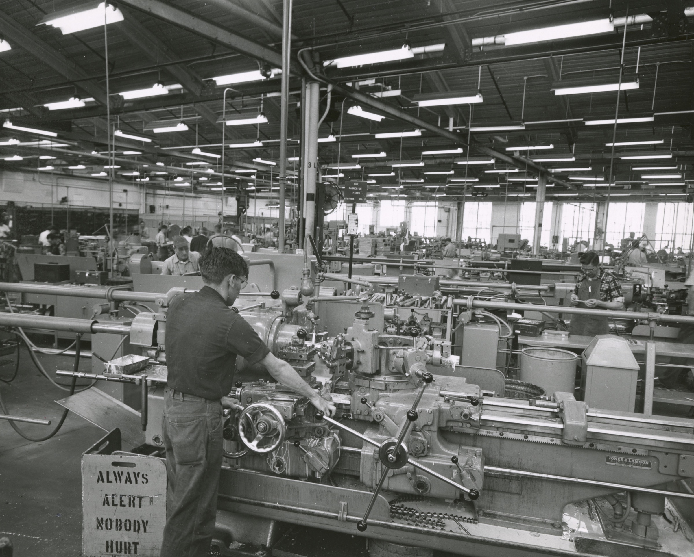 Rows of workers operating lathes and other machinery across the Western Electric Tarheel Army Missile Plant floor in 1953.