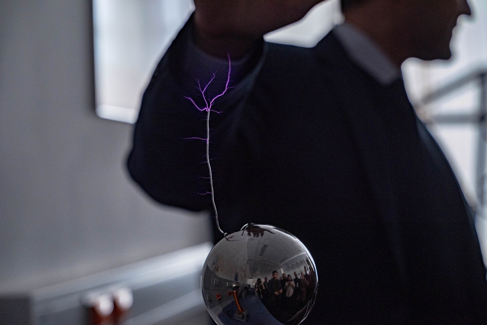 Bright branching electric spark crosses an air gap between conducting laboratory electrodes.