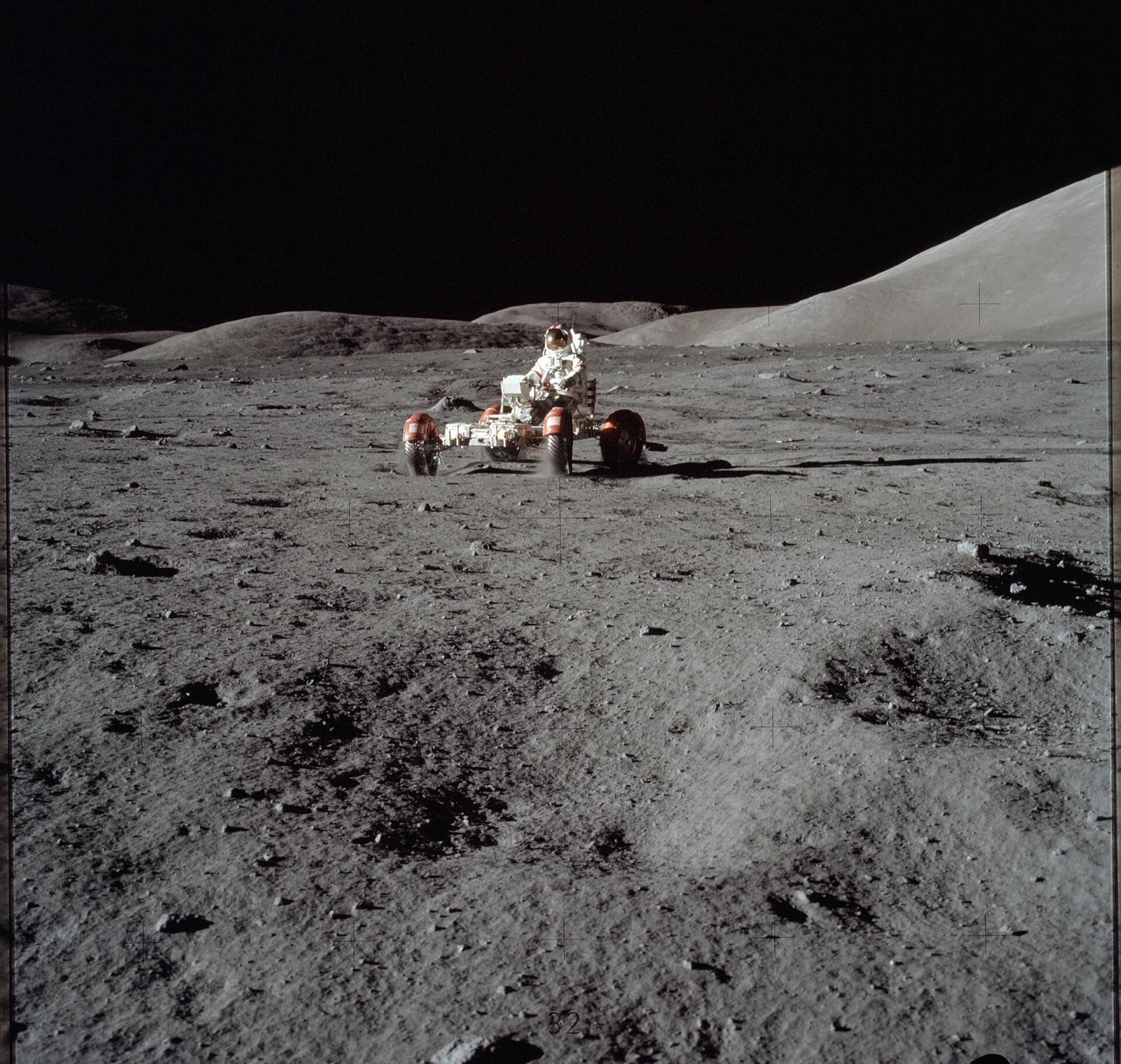 Apollo 17 astronaut Eugene Cernan drives the Lunar Roving Vehicle across the lunar surface.