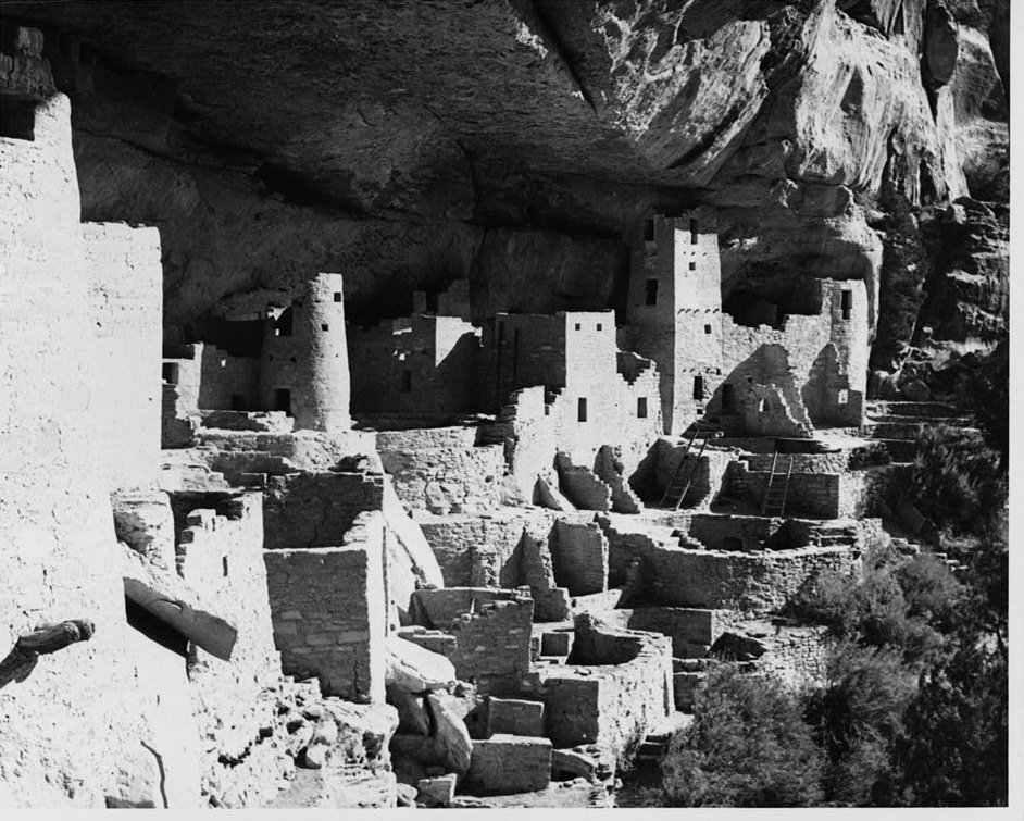 Stone rooms and towers built into a large cliff alcove at Mesa Verde